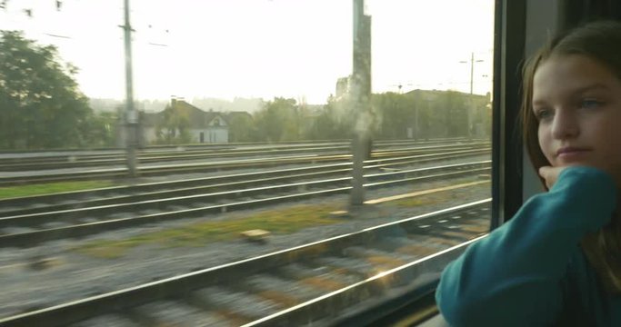 A pensive teenage girl look through the windows while traveling.
