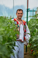 Romanian farmer in traditional costume in his greenhouse