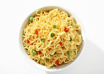 Vermicelli with green peas and chopped bell pepper in white bowl on white background. Close up, top view, high resolution product.