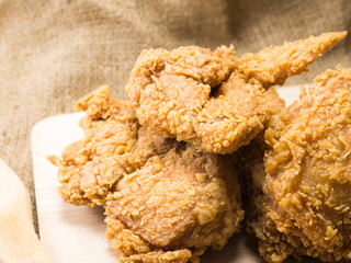 fried chicken on a chopping broad  set on a wood background
