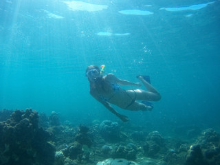 Underwater shot of the woman moving on the breath hold in the depth. Amed village, Bali, Indonesia