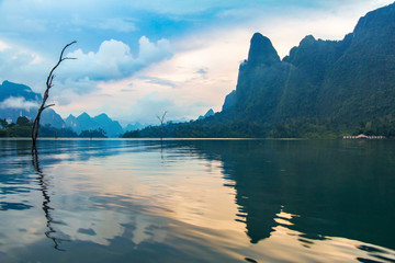 Cheow lan lake on the sunset, Thailand. Orange clouds reflected in the water, gorgeous scenery