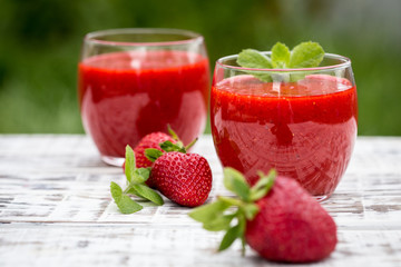 strawberry smoothie on a light wooden background