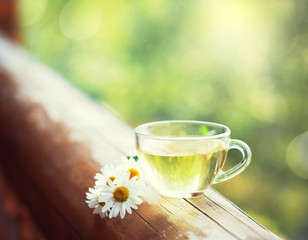 Cup of herbal tea on the railing of the balcony. Toned image