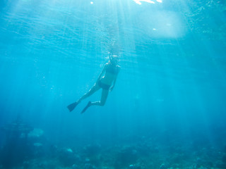 Obraz premium Underwater shot of the woman moving on the breath hold in the depth. Amed village, Bali, Indonesia