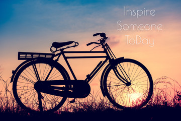Fototapeta na wymiar beautiful landscape image with Bicycle at sunset in vintage tone style ; life quote. Inspirational quote. Motivational background