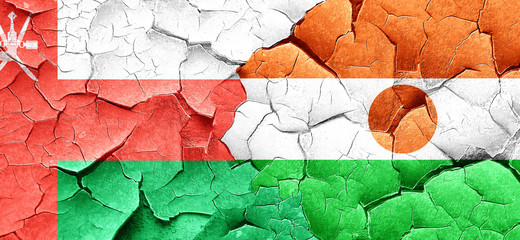 Oman flag with Niger flag on a grunge cracked wall