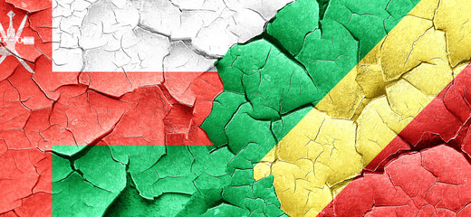 Oman flag with congo flag on a grunge cracked wall