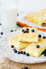 
rustic grated cheese cake with berries , with blueberries and milk on a wooden background