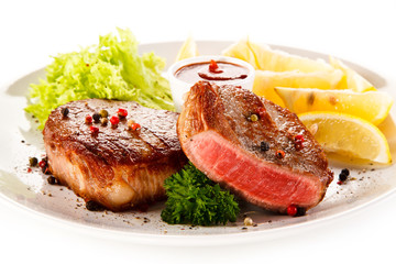 Grilled steaks on white background