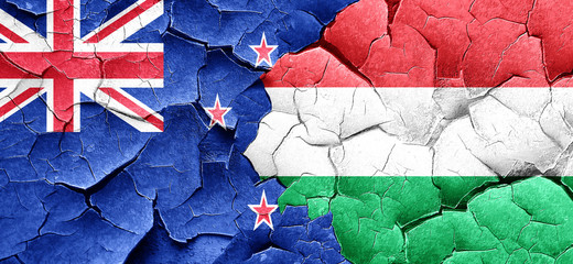 New zealand flag with Hungary flag on a grunge cracked wall