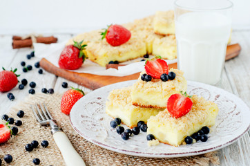 
rustic grated cheese cake with berries , with strawberries , blueberries and milk on a wooden background