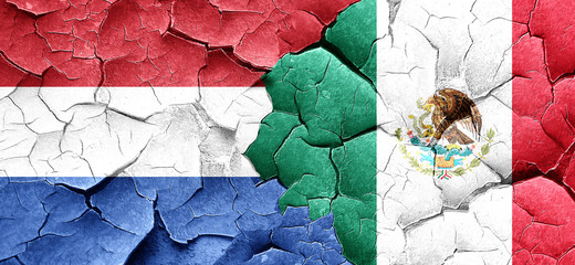 Netherlands flag with Mexico flag on a grunge cracked wall