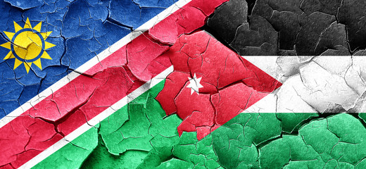 Namibia flag with Jordan flag on a grunge cracked wall