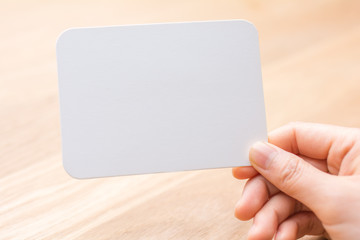 woman's hand holding white blank paper