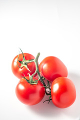Branch of ripe tomatoes on white background