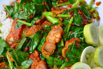 stir fried Chinese kale and crispy pork in spicy curry on rice