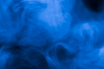 Cloud of smoke on black background. Selective focus. Toned