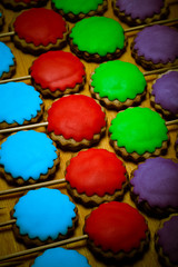 Gingerbread cookies with colored mastic on sticks on the old woo