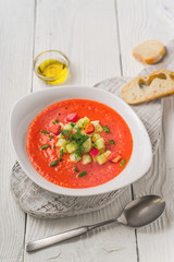 Vegetable soup gazpacho, stand, bread, spoon on white boards