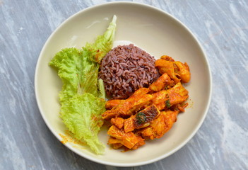 stir fried salmon in curry paste and brown rice on plate