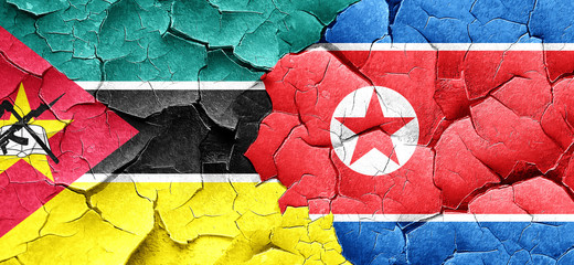 Mozambique flag with North Korea flag on a grunge cracked wall