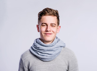 Boy in gray sweater and scarf, young man, studio shot