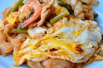 stir fried large noodle seafood and egg with sukiyaki sauce on dish