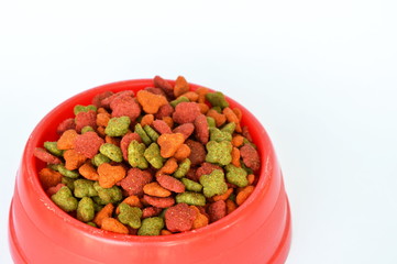 cat dry food in red plastic bowl on white background