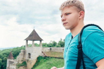 Young man tourist on the old castle territory