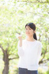 ガッツポーズをする女性、新緑