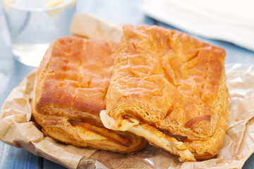 bread with ham and cheese with glass of water on blue wooden background