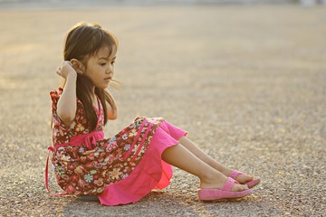 Girl sitting at the public park the evening .
