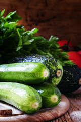 Small green zucchini on the wooden cutting board, selective focu