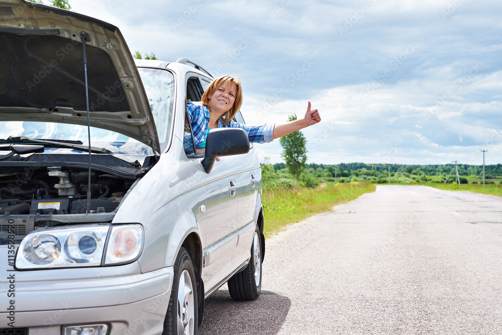 Wall mural Woman waiting to help and thumbs from car