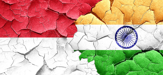 monaco flag with India flag on a grunge cracked wall