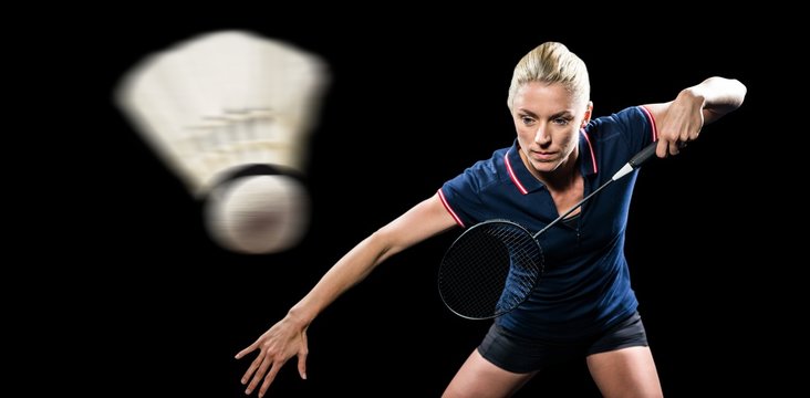 Badminton player playing badminton on black background