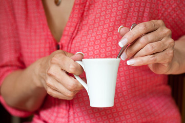 détail mains de femme et tasse de café
