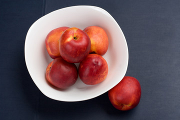 The simple food composition with nectarines on the unique backing closeup 