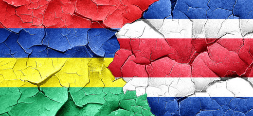 Mauritius flag with Costa Rica flag on a grunge cracked wall