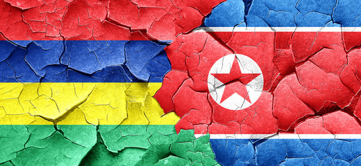 Mauritius flag with North Korea flag on a grunge cracked wall