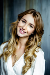 Portrait of young beautiful woman. Long, light, wavy hair and makeup