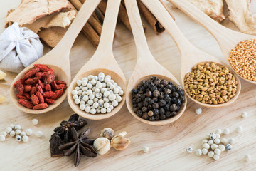 Peppercorn in wooden spoon with various ingredient in wooden spoon
