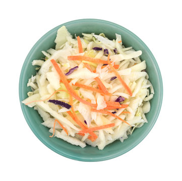 Bowl filled with coleslaw isolated on a white background top view.