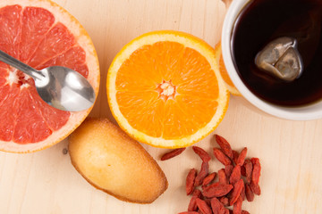 Healthy breakfast : tea, fresh fruits, madeleine, goji berries