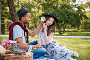 Happy young couple relaxing and having picnic in park