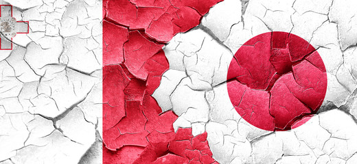 Malta flag with Japan flag on a grunge cracked wall