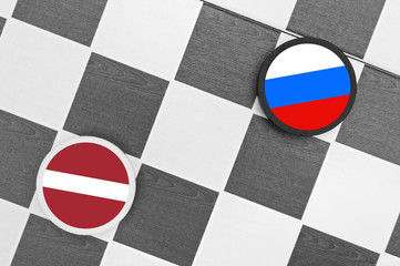 Naklejka premium Draughts (Checkers) - Russia vs Latvia - russian sphere of influence - west / east heading of latvian country and partnership, diplomacy, confrontation and hybrid war 