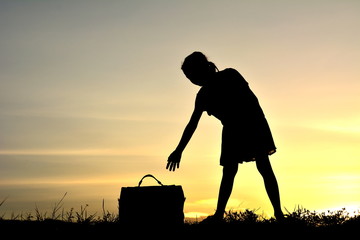 Silhouette a girl with bag at sky sunset