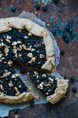 Homemade blueberry galette on a paper on a dark background